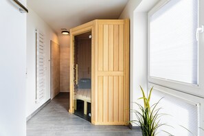 A hallway with a wooden cabinet, a radiator, and a potted plant. - A Getaway in Büsum - Vacation Home with Sauna & Fireplace (Büsum)