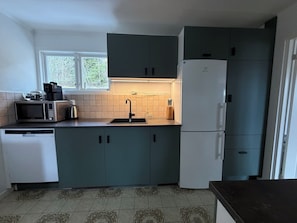Cocina compacta equipada con microondas, lavabo y refrigerador.