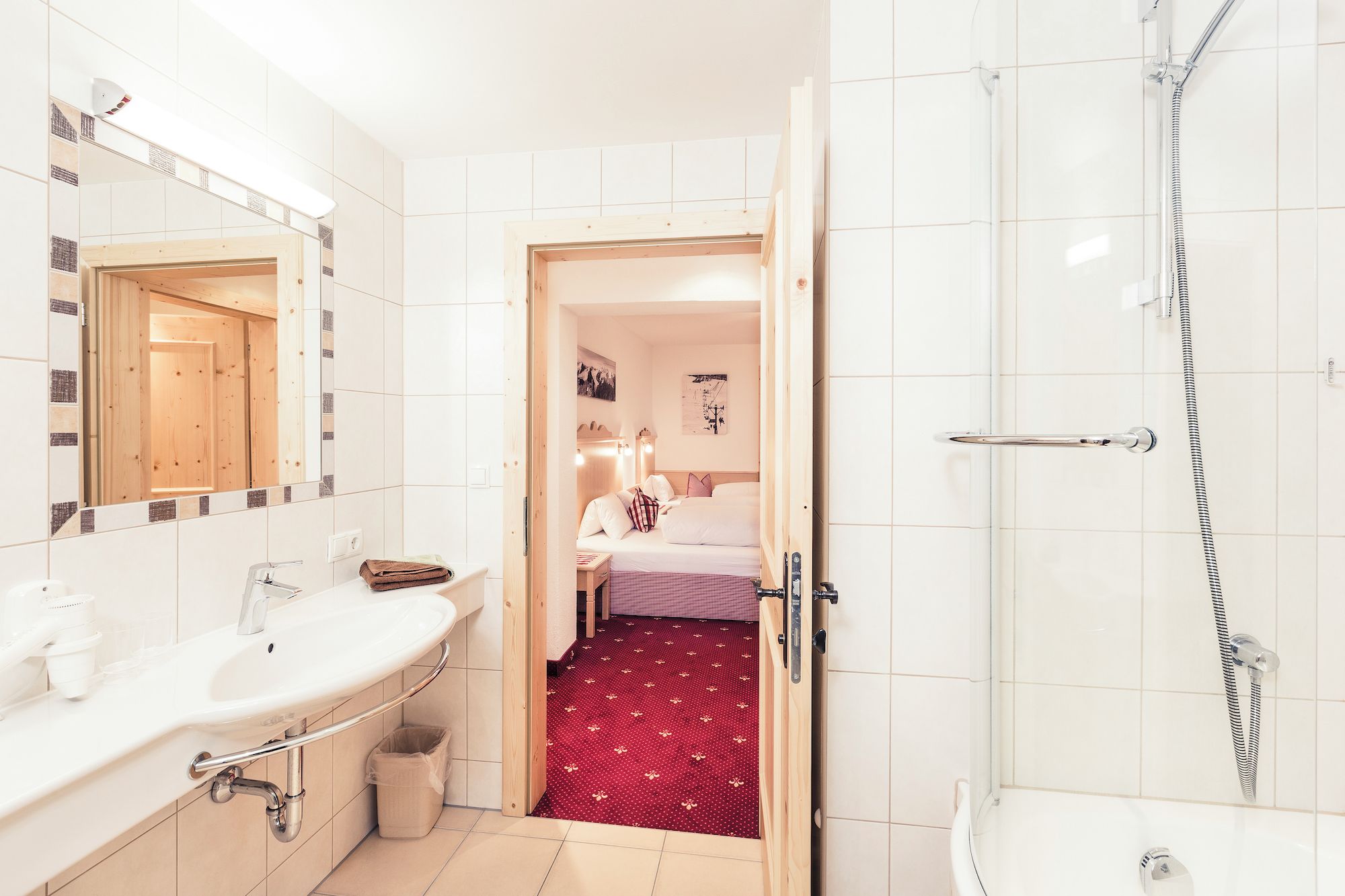 Ein Badezimmer mit Dusche, Waschbecken und Spiegel.