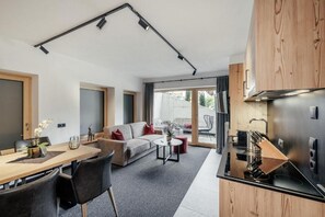 Una cocina moderna con encimera negra y electrodomésticos de acero inoxidable.