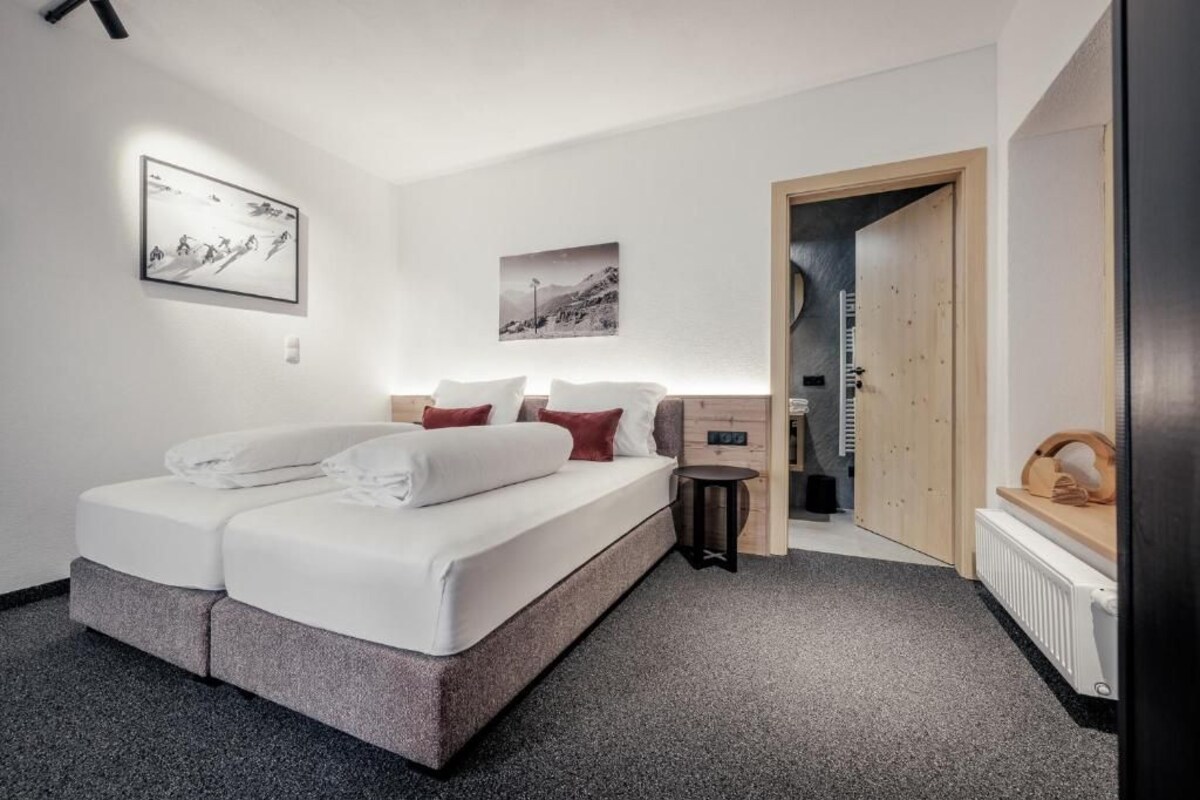 Een moderne slaapkamer met een bed, een klein nachtkastje en een kledingkast.