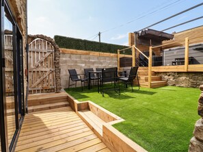 A patio with a wooden deck, a seating area with chairs and a table, and a barbecue grill. - 2 Makant Street (Bolton)