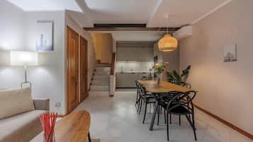 Ein modernes Wohnzimmer mit einer Couch, einem Holz-Couchtisch und einem Essbereich mit Stühlen und einem Tisch.