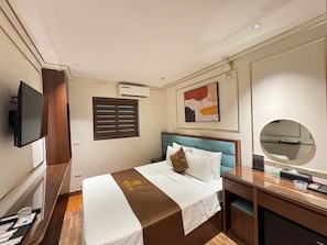 A hotel room with a bed, a TV, a desk, and a mirror. - 89 Hotel Luxury (Phuong Lieu)