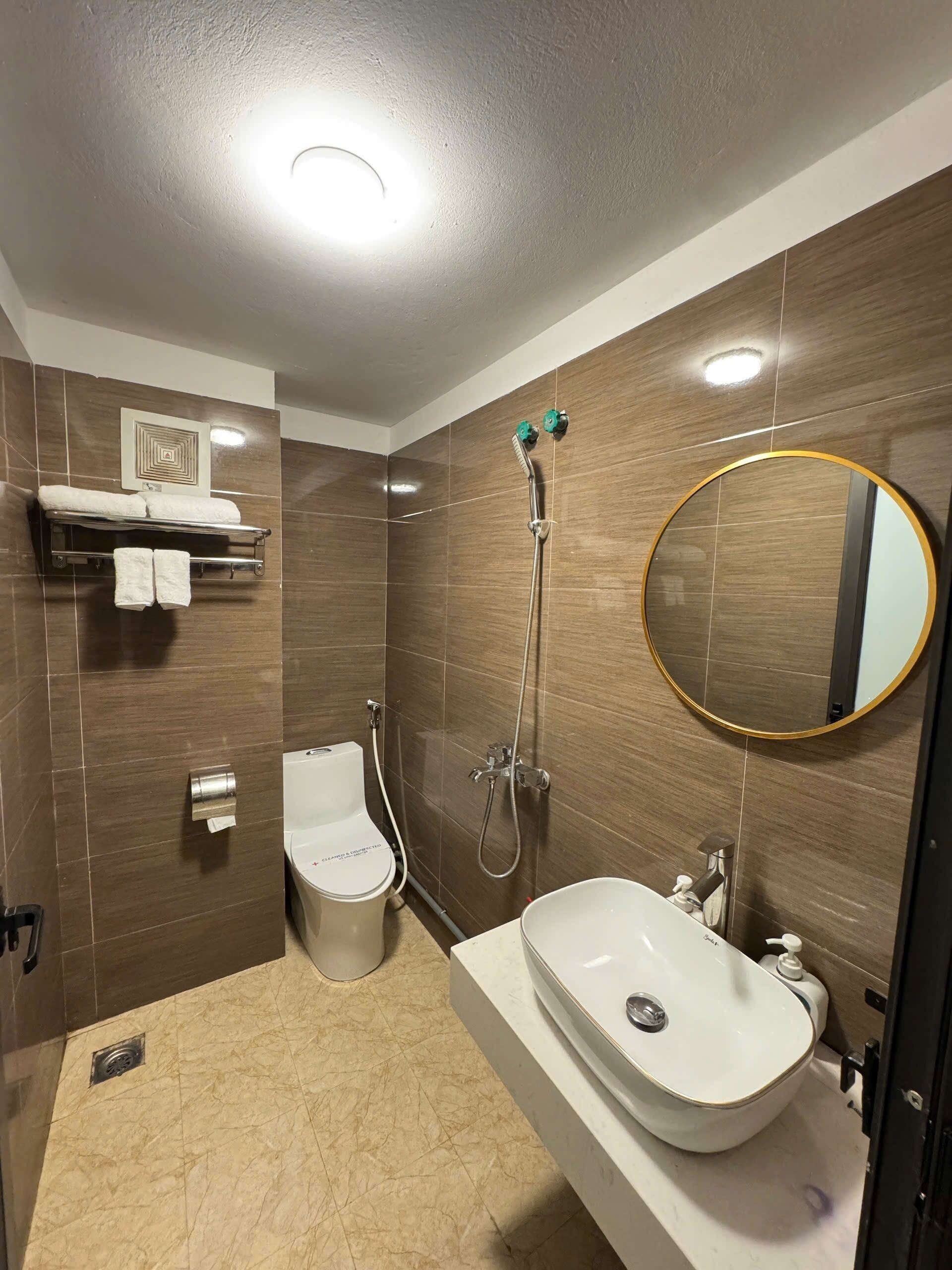 A modern bathroom with a toilet, sink, and shower.