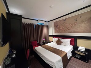 A hotel room with a bed, a TV, a desk, and a wall-mounted artwork. - 89 Hotel Luxury (Phuong Lieu)