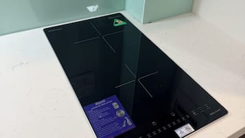 Una cocina moderna con placa de inducción integrada y un protector contra salpicaduras de acero inoxidable.