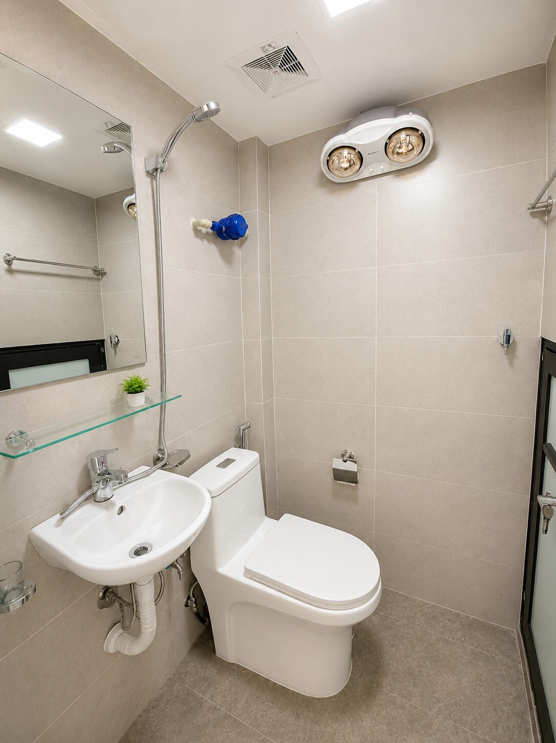 A modern bathroom with a shower, toilet, and sink.