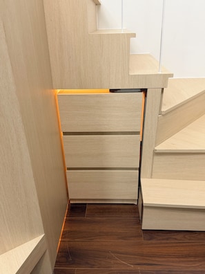 A wooden staircase with a built-in storage compartment.