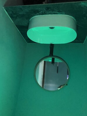 Ett tak med en rund spegel och en lampa.