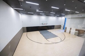 A basketball court with a net, a grey mat, and a wall with a window. - Downtown Miami Luxury 1 Bed w/ Free Parking & Pool (Miami)