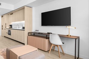 A modern kitchen with built-in appliances, a dining area with a table and chairs, and a large flat-screen TV mounted on the wall. - Downtown Miami Luxury 1 Bed with Free Parking and Gym Pool Basketball Court (Miami)