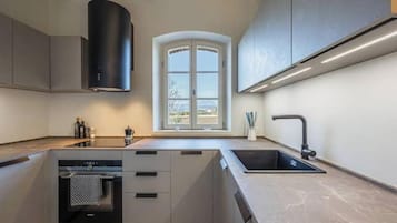 Eine moderne Küche mit Einbauofen, Fenster mit Aussicht und Spüle.
