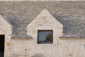 A stone building with a triangular gable and a small window.
