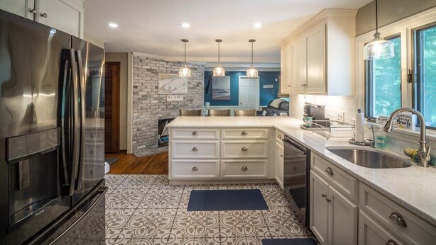 A modern kitchen with stainless steel appliances, a central island, and a view of the outdoors through a window. - Connecticut Beach Home (Old Lyme)