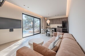 Ein modernes Wohnzimmer mit einer großen Couch, einem Essbereich und einer Küche.