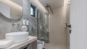 A modern bathroom with a large sink, a mirror, and a glass-enclosed shower. - Metatulia 8 (Agios Vasileios)