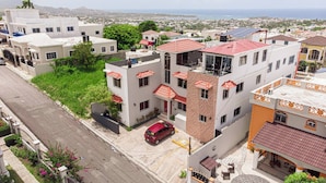 Un barrio residencial con edificios de varios pisos, una calle y vistas a la costa.
