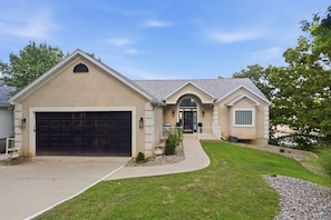 A two-story house with a garage, a front entrance, and a small porch. - Osage Beach, 4b, Private cove, sleeps 10 (Osage Beach)