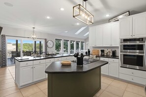 A modern kitchen with white cabinetry, a large island, and built-in appliances. - Osage Beach, 4b, Private cove, sleeps 10 (Osage Beach)
