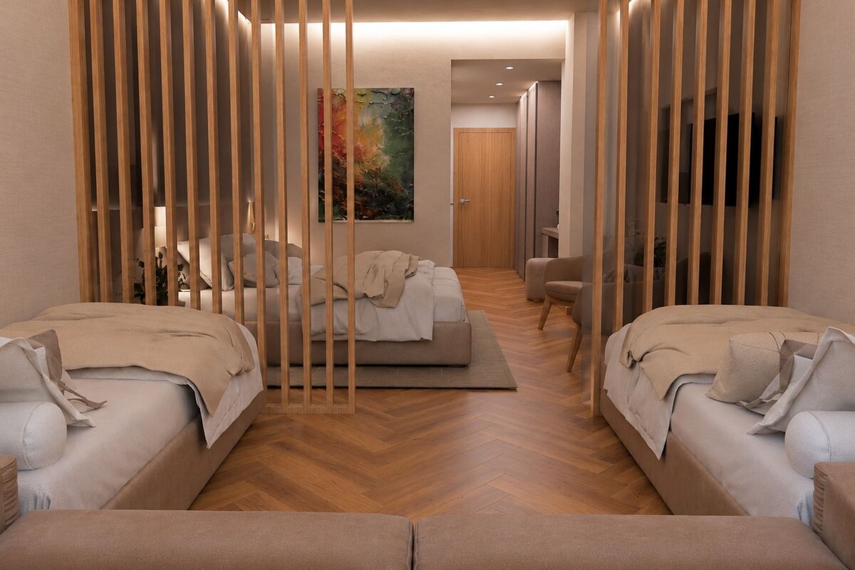 Una habitación de hotel moderna con dos camas, un sofá, un televisor y un cuadro en la pared.