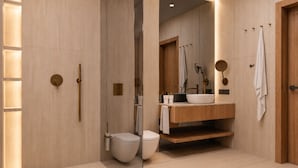 Ein modernes Badezimmer mit einem Holzlagerflächen, einem weißen Waschbecken und einer Toilette.
