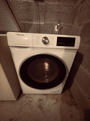 Una lavadora Hisense con panel de control y puerta de acero inoxidable.