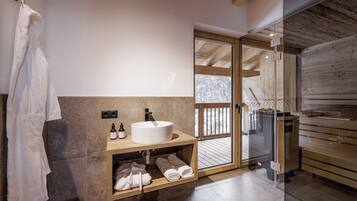 Ein modernes Badezimmer mit einem großen Waschbecken, Holzregalen und einer Glastür, die auf einen Balkon führt.