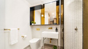 Une salle de bain moderne avec des toilettes, un lavabo et un miroir.