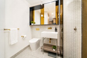 Ein modernes Badezimmer mit Toilette, Waschbecken und Spiegel.