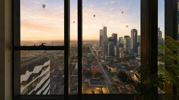 A large window with a cityscape view, including buildings and hot air balloons.