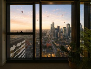 Ein großes Fenster mit Blick auf die Stadt, einschließlich Gebäude und Heißluftballons.