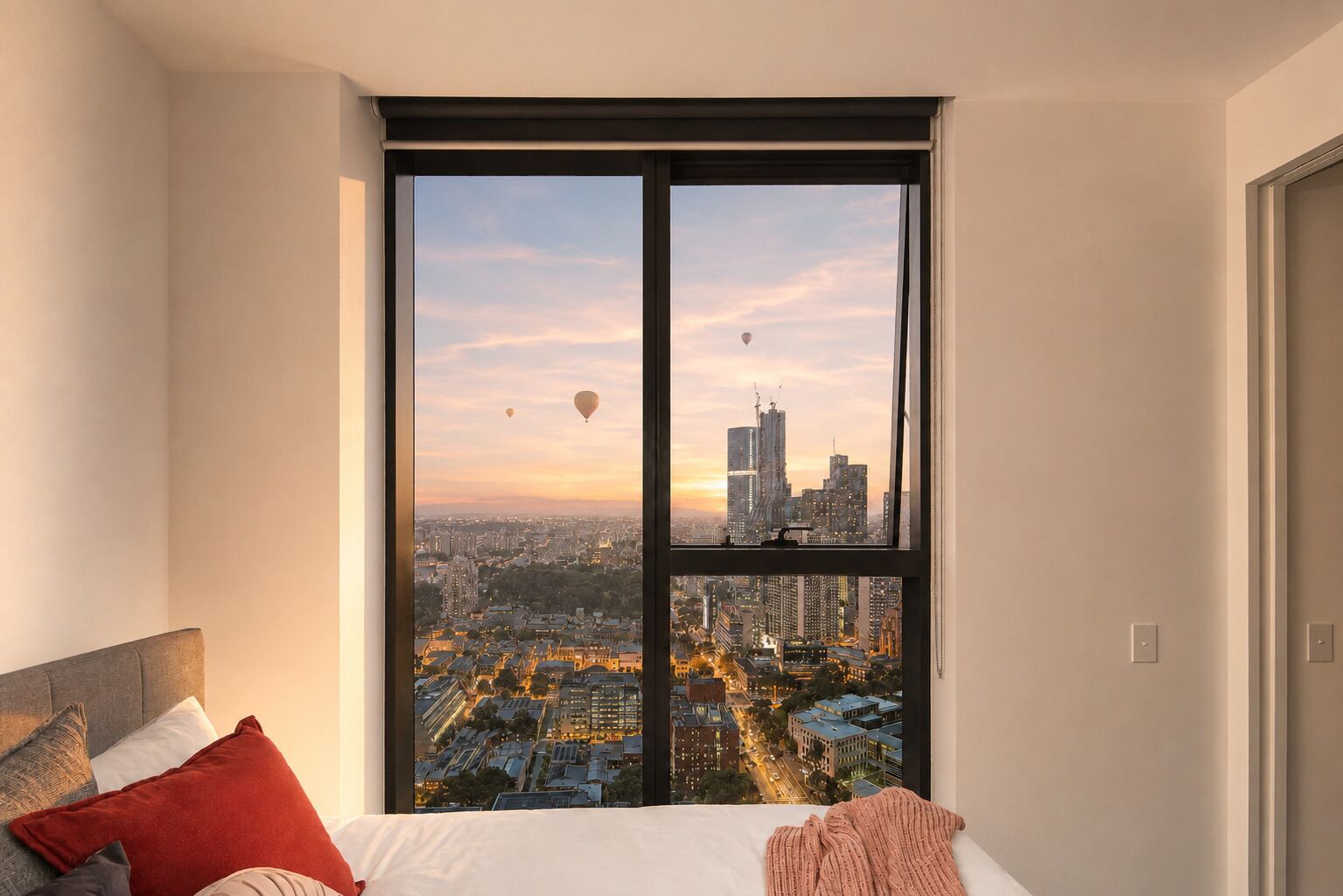 A bedroom with a large window overlooking a cityscape at sunset.