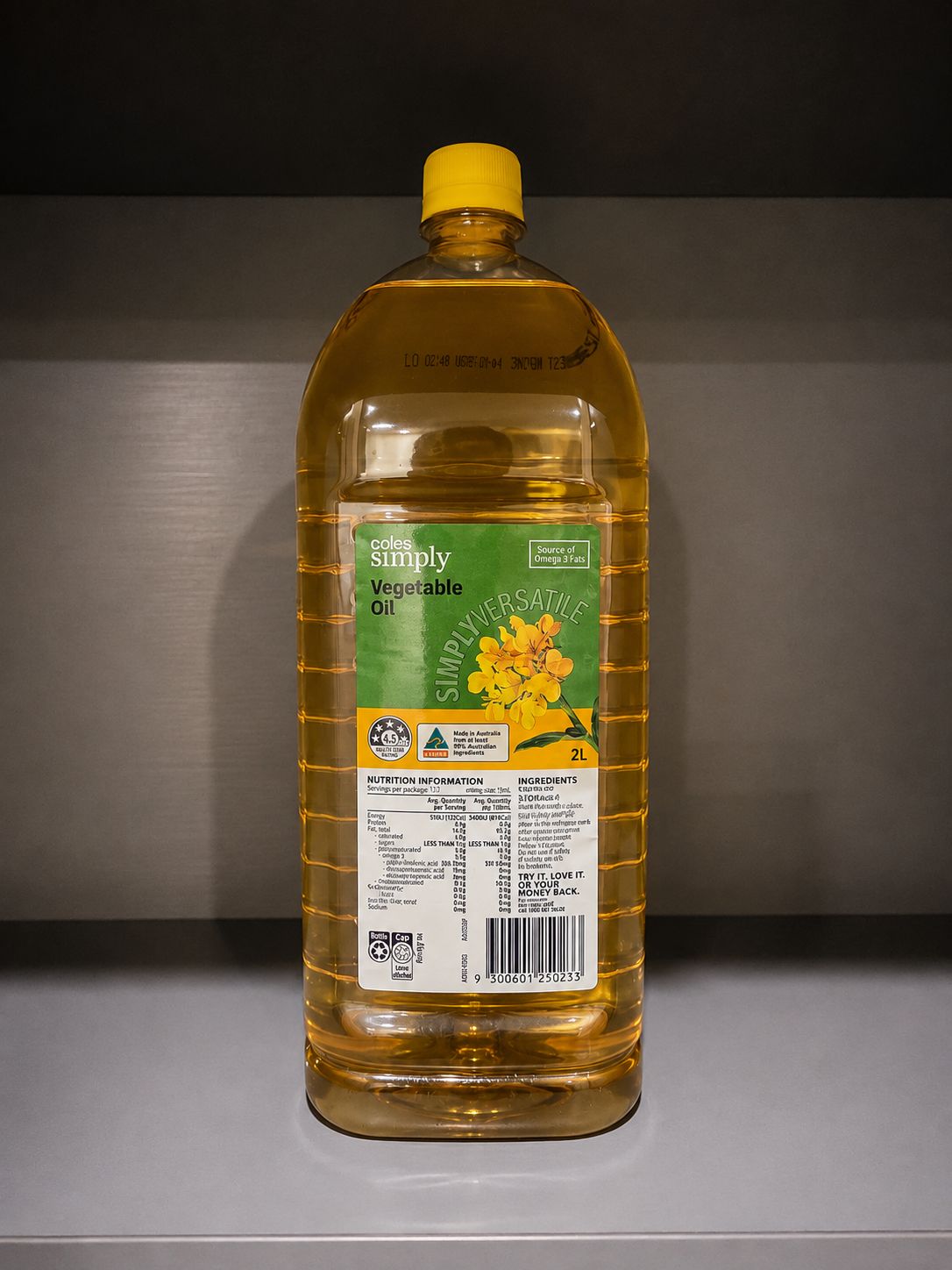 A bottle of Coles Simply Vegetable Oil with a yellow cap, placed on a shelf.