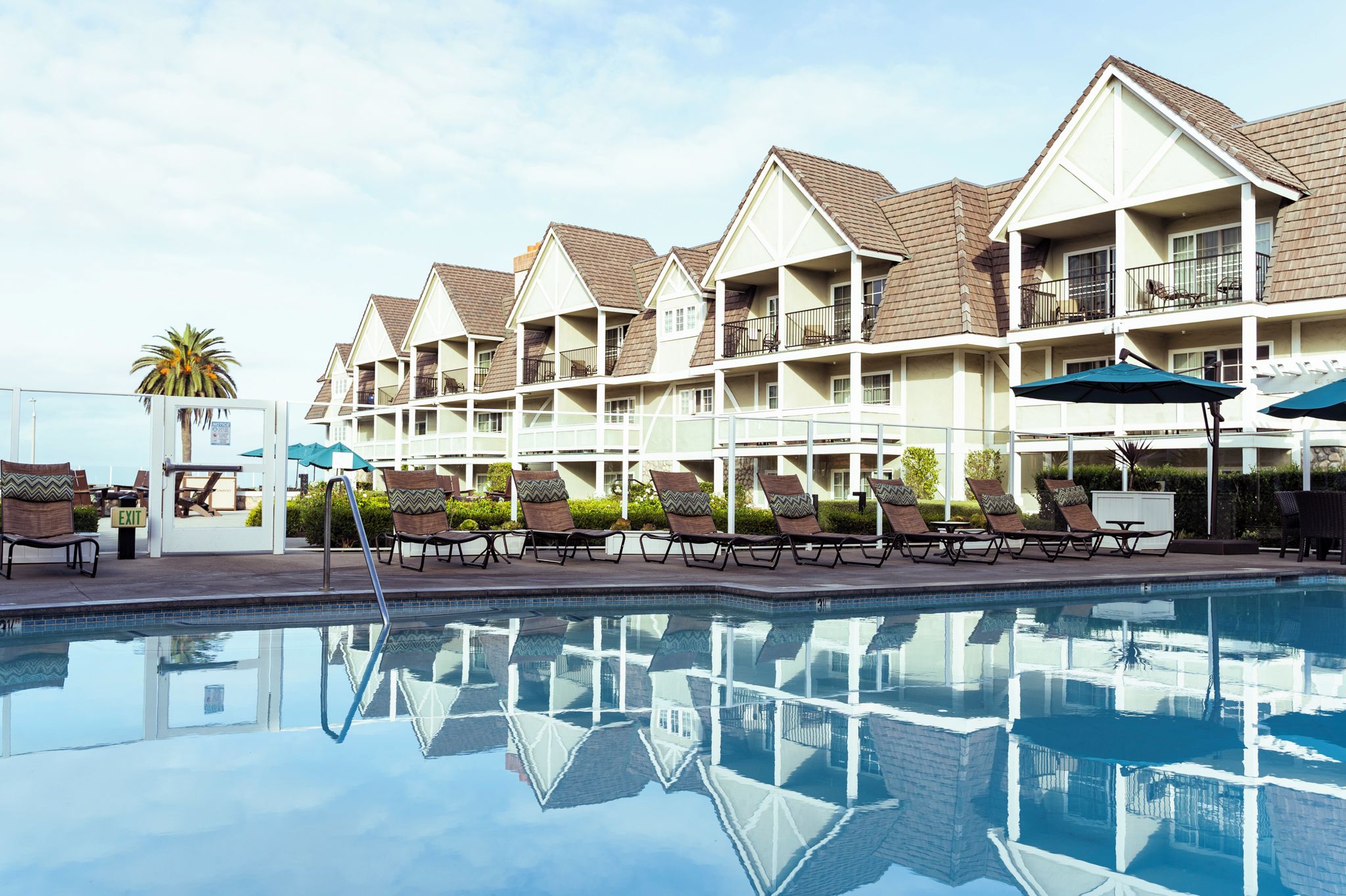 A hotel with a swimming pool, multiple balconies, and outdoor seating.