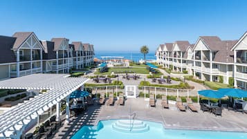 Een resort met een zwembad, ligbedden en uitzicht op de oceaan.