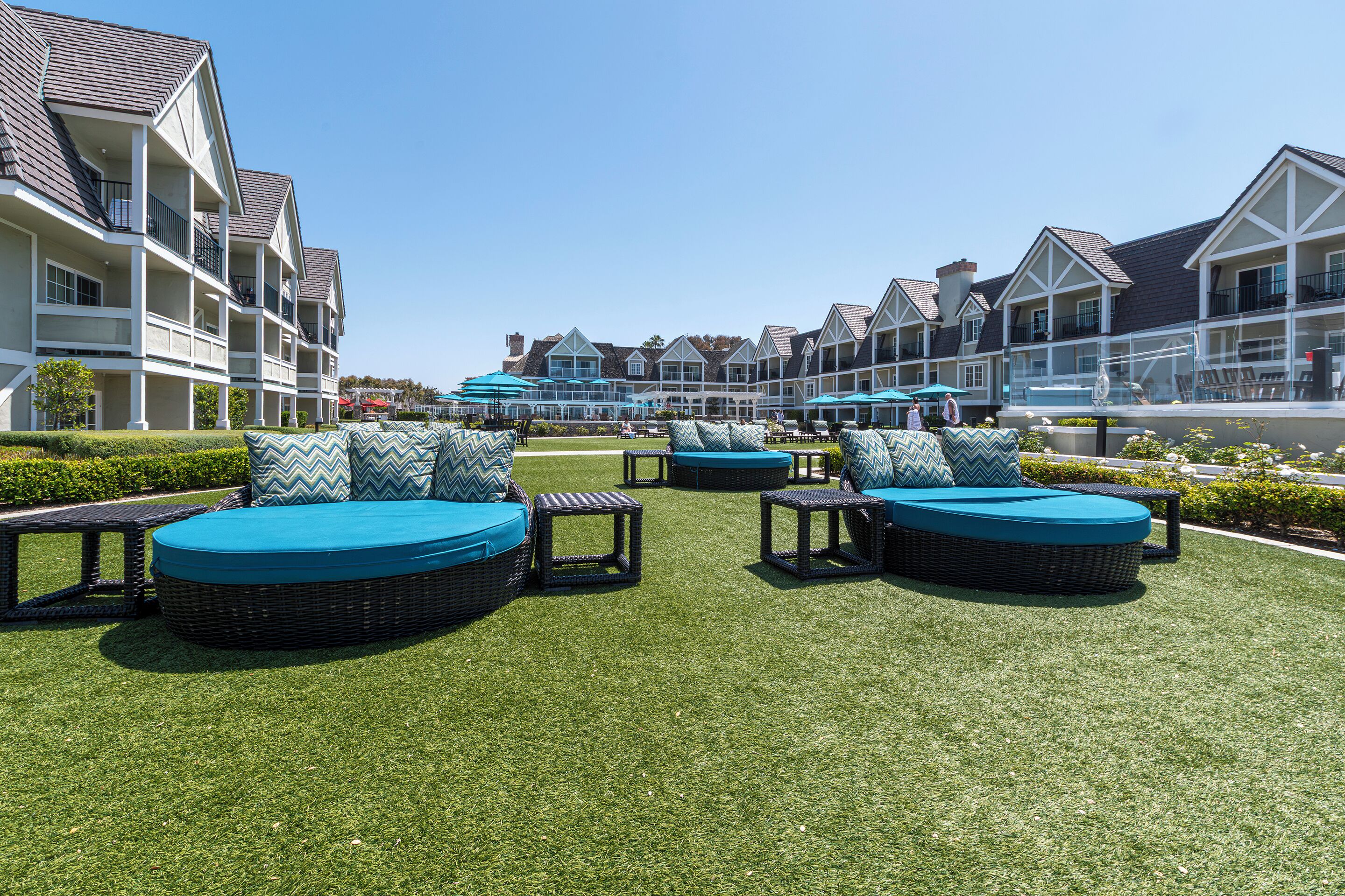 A courtyard with outdoor seating and a pool area, surrounded by multi-story buildings with balconies.