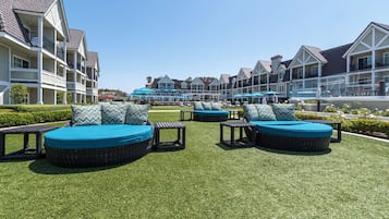 A courtyard with outdoor seating and a pool area, surrounded by multi-story buildings with balconies.