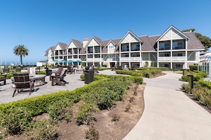 Ein Resort mit mehrstöckigen Gebäuden, Außenbereichen zum Sitzen und einem Weg zum Strand.