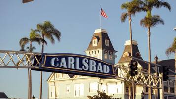 Un panneau de signalisation indiquant « CARLSBAD », un feu de circulation et un bâtiment sur lequel flotte un drapeau.