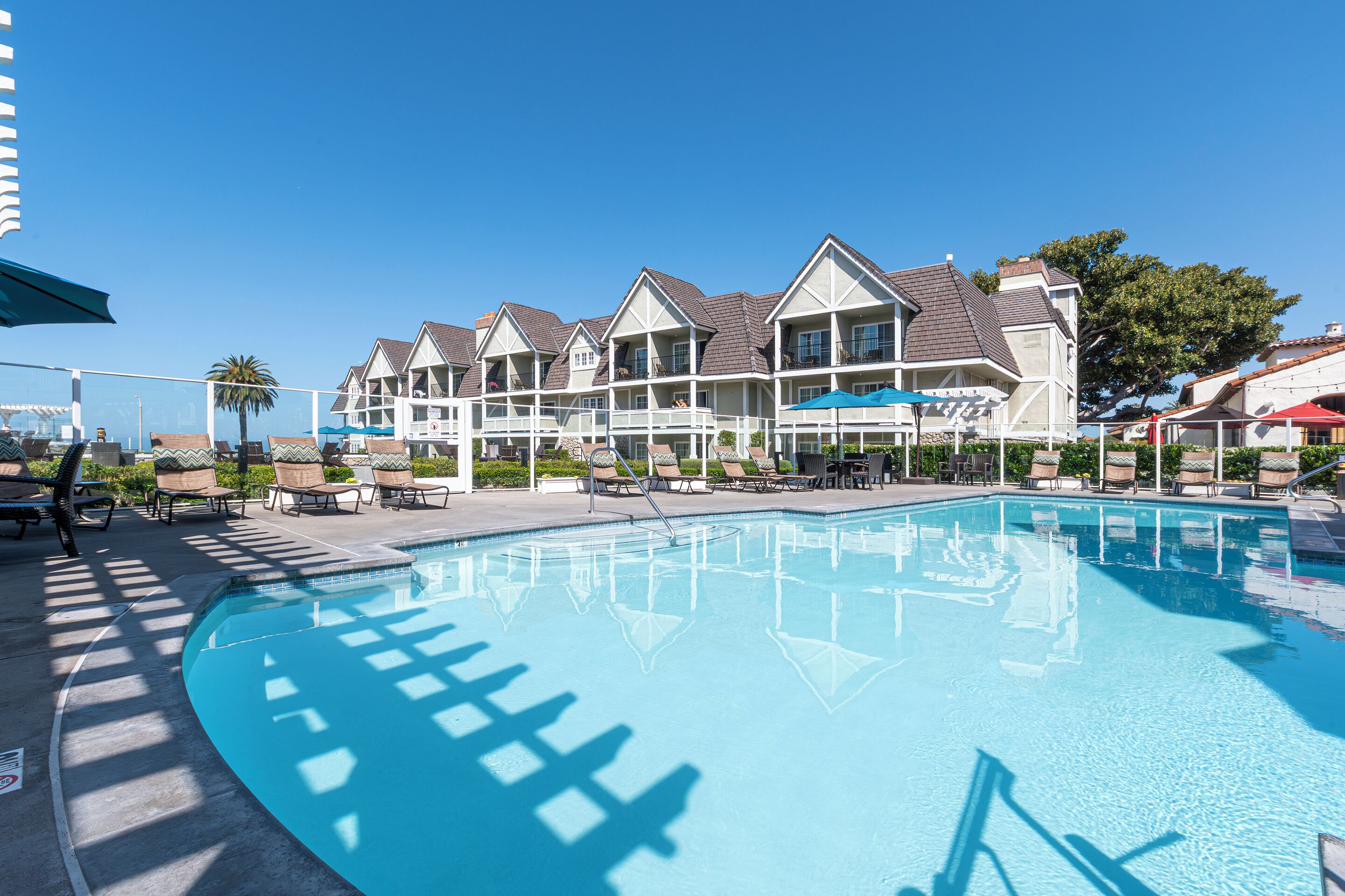 Ein Hotel mit Schwimmbad, mehreren Balkonen und Außenbereichen zum Sitzen.