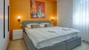 A bedroom with a large bed, two bedside tables, a painting on the wall, and a window with curtains. - Holiday property in typical regional style (Poreč)