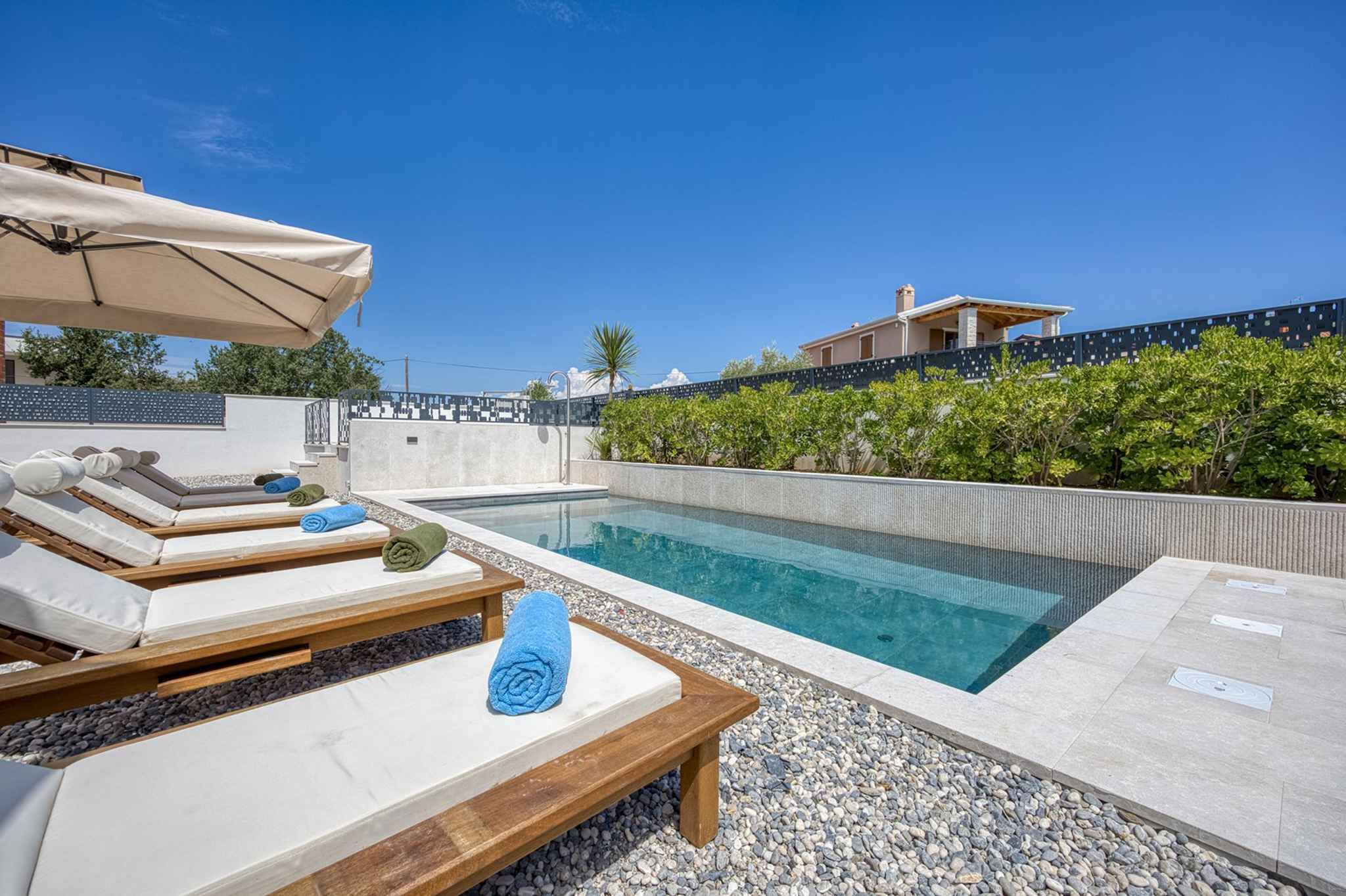 Un espace aménagé au bord de la piscine, avec des chaises longues, une table et une pergola.