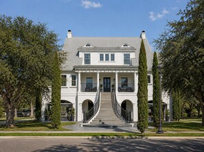 A two-story building with a central staircase, a front porch, and a symmetrical facade.