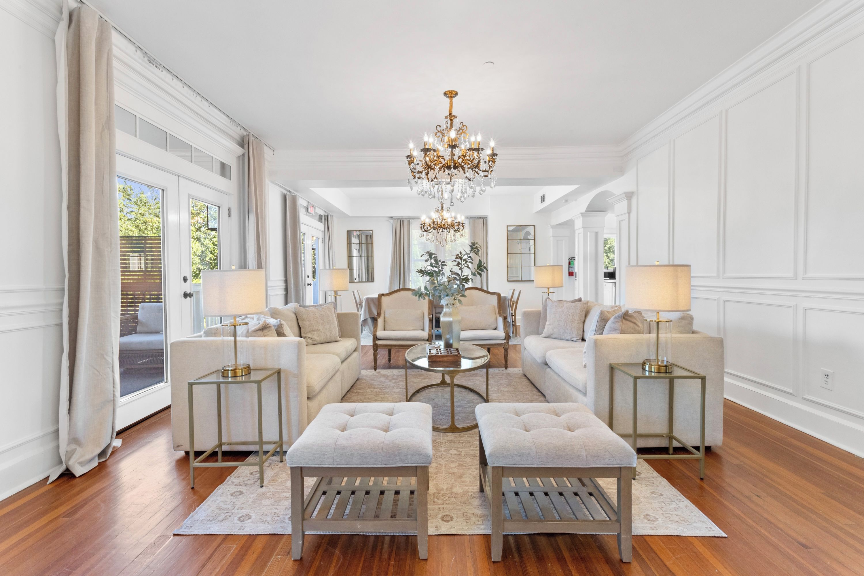 Amplia sala de estar con candelabro, sofás, sillones y una mesa de centro.