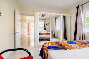 Ein Hotelzimmer mit einem Bett, einem Sessel, einem Kleiderschrank und einem durch eine offene Tür einsehbaren Badezimmer.