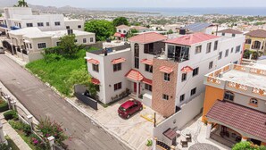 Área residencial com edifícios altos, uma rua e vista para a orla.