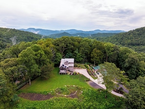 Ein Haus, umgeben von dichtem Wald, mit freiem Blick auf die umliegenden Berge.