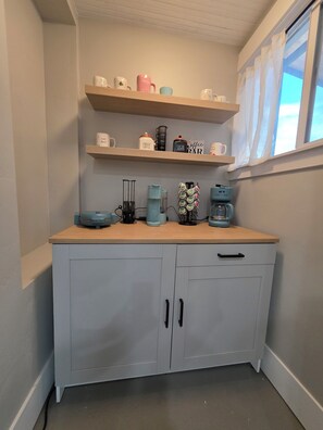 A kitchen with a wooden countertop, a coffee machine, and a shelf with various mugs. - Charming 4-bedroom house with AC in Heber City (Heber City)