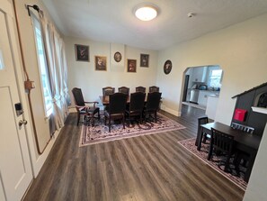 A dining area with a wooden table and chairs, a patterned rug, and wall-mounted artwork. - Charming 4-bedroom house with AC in Heber City (Heber City)